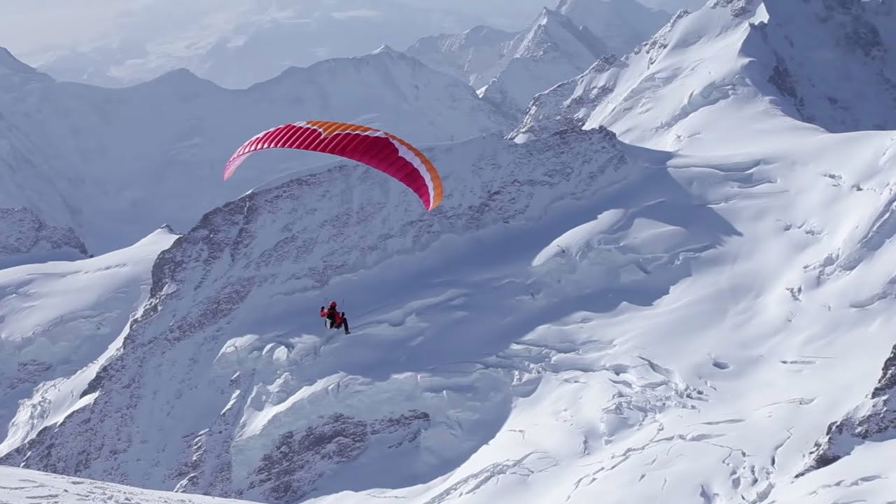 Backdrop for Ueli Steck - Paraglides Between Mountains In The Swiss Alps